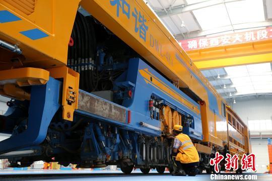 圖為工人正在清理大型養(yǎng)路機(jī)械。　張遠(yuǎn) 攝